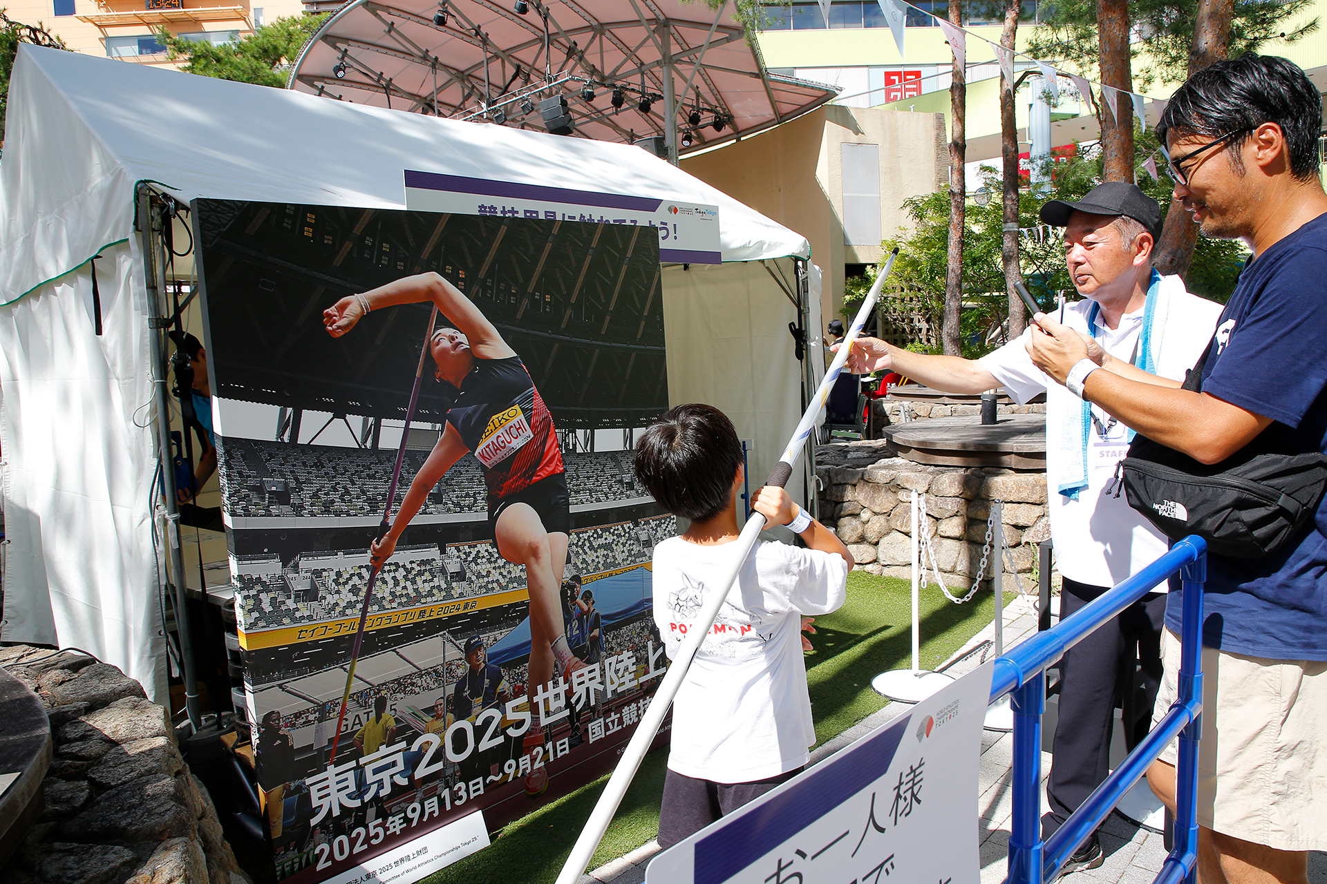 北口選手のパネル前でやりを持っている男の子の写真