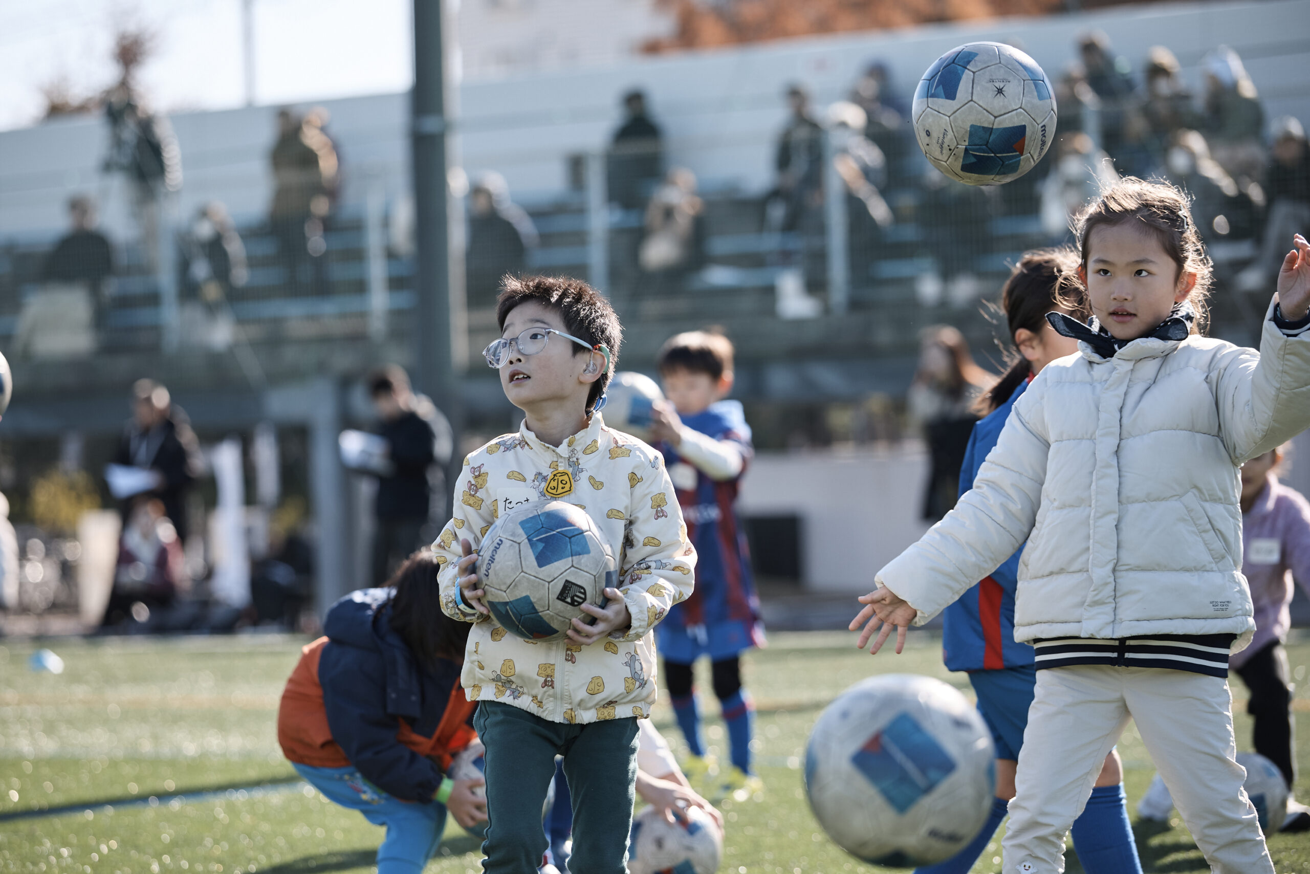 ボールを持っている男の子とリフティングをしている女の子の写真