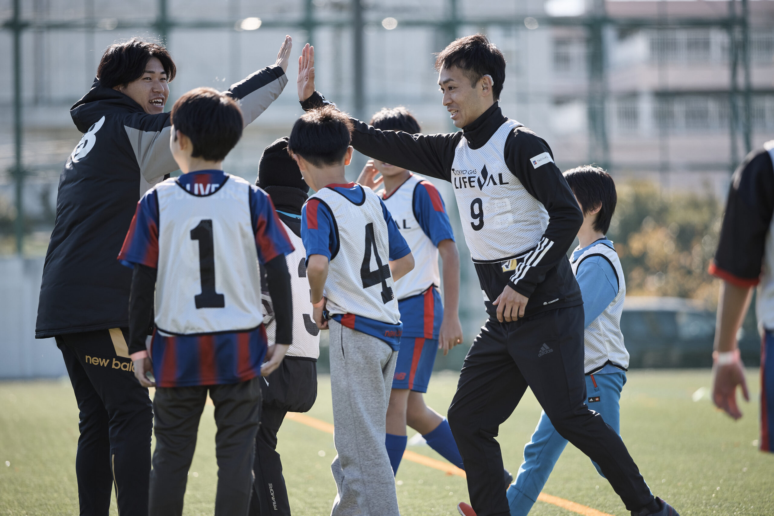 参加者の横でハイタッチをしている設楽選手の写真