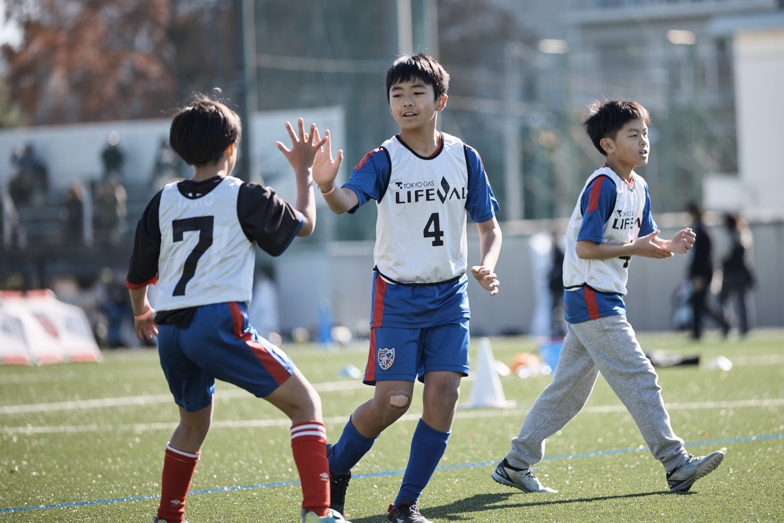 白いビブスの男の子2人がハイタッチをしている写真