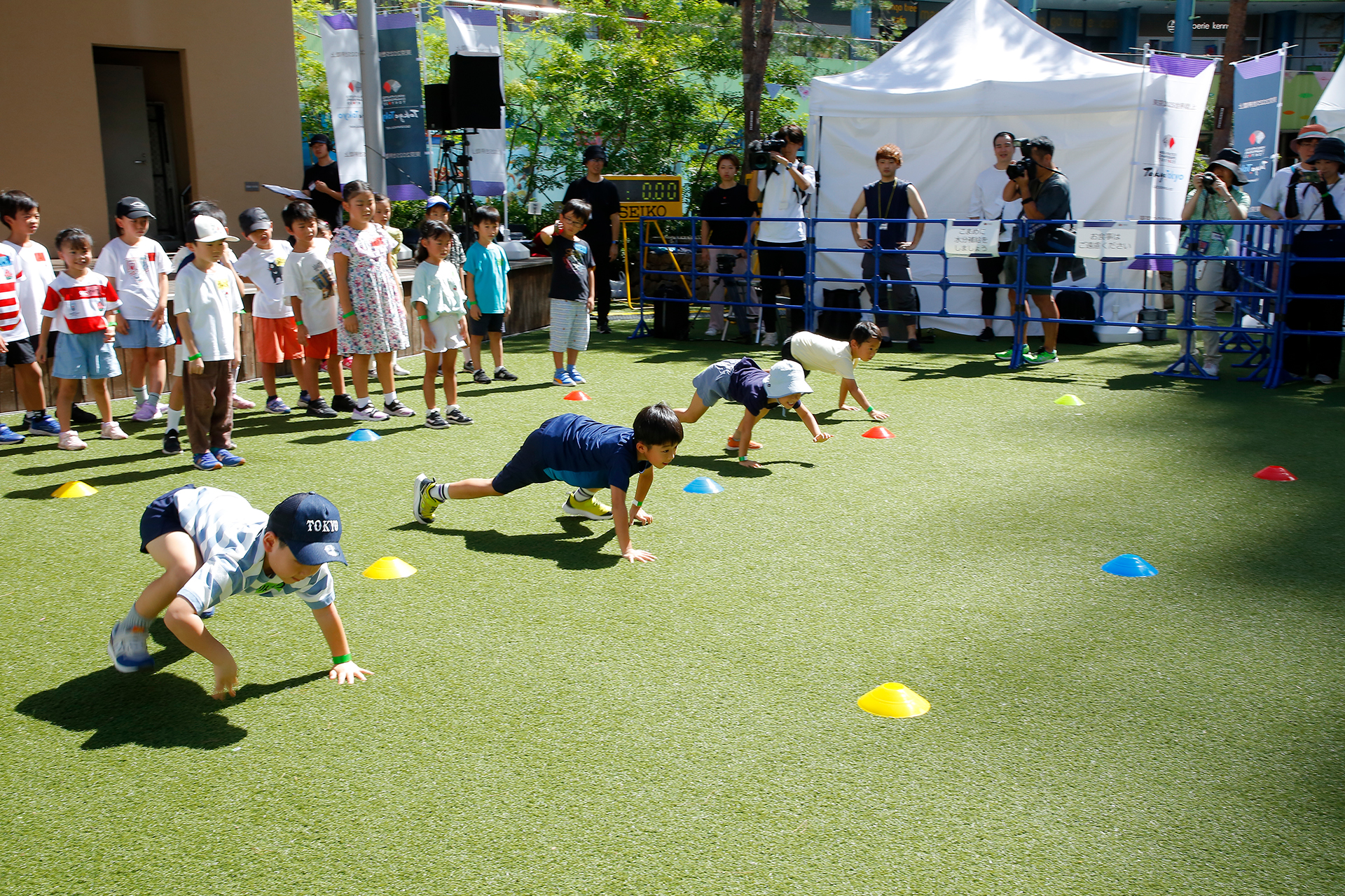 四足歩行の練習をする4人の子どもたちと、その後ろに順番に並んでいる子どもたちの写真