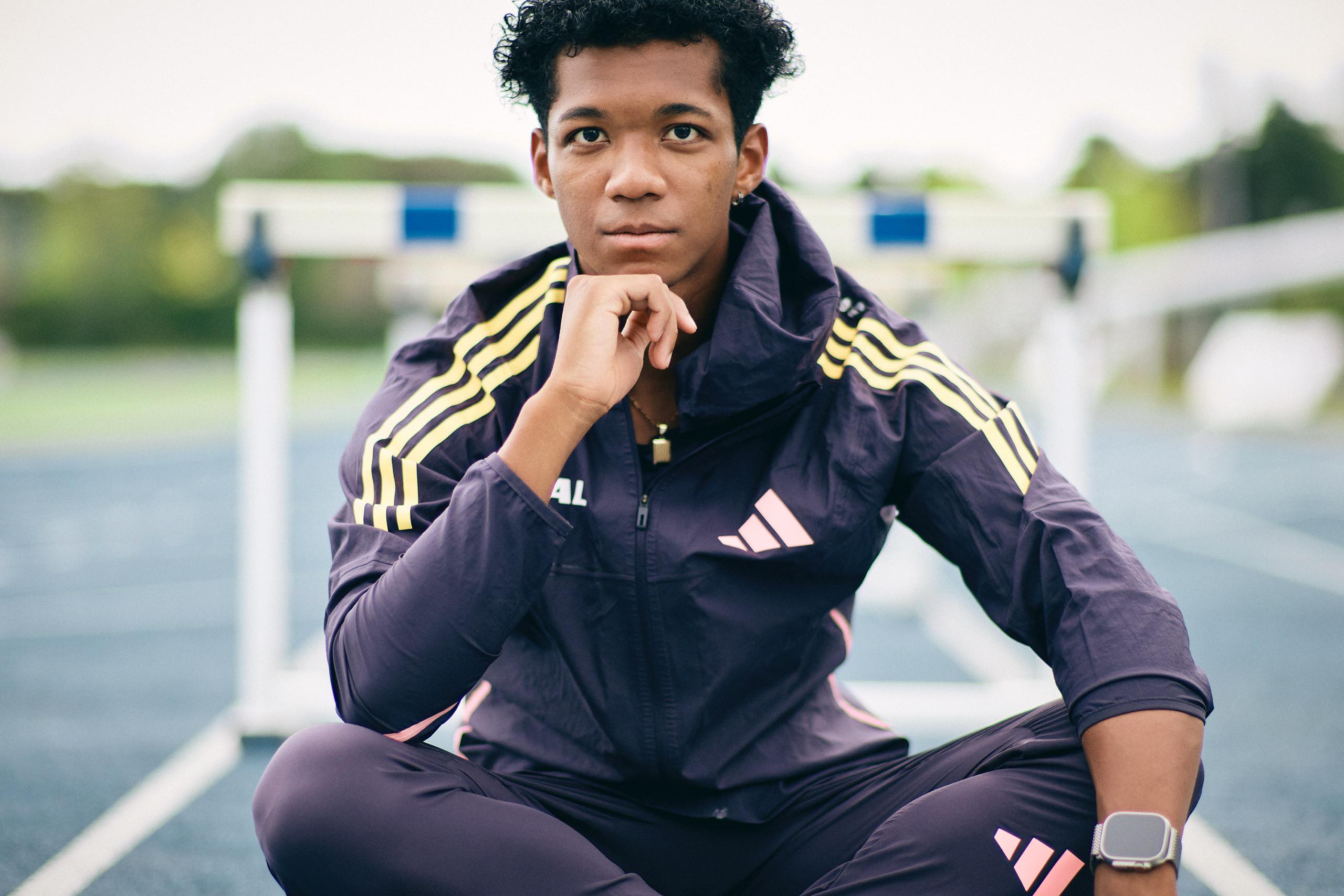 The photo of Muratake sitting cross-legged in front of the hurdles.