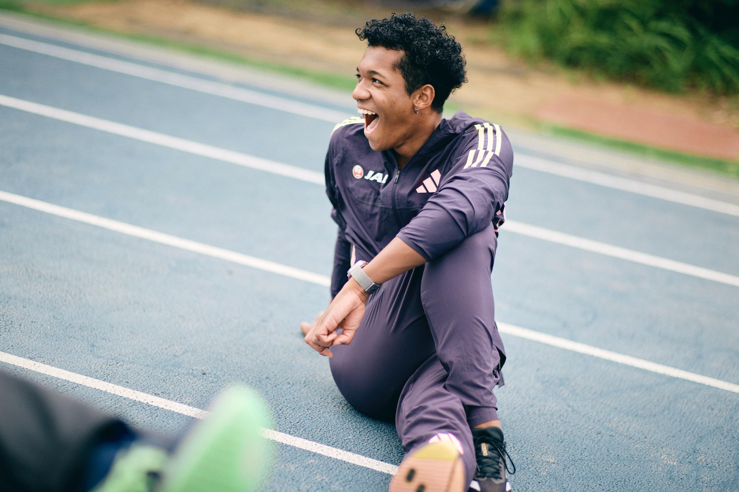 The photo of Muratake sitting on the track and stretching.