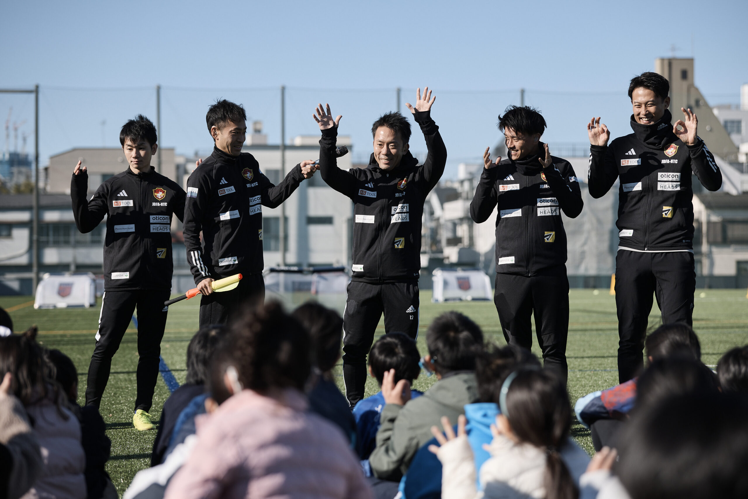 子供たちの前で紹介される5名のデフサッカー日本代表選手の写真