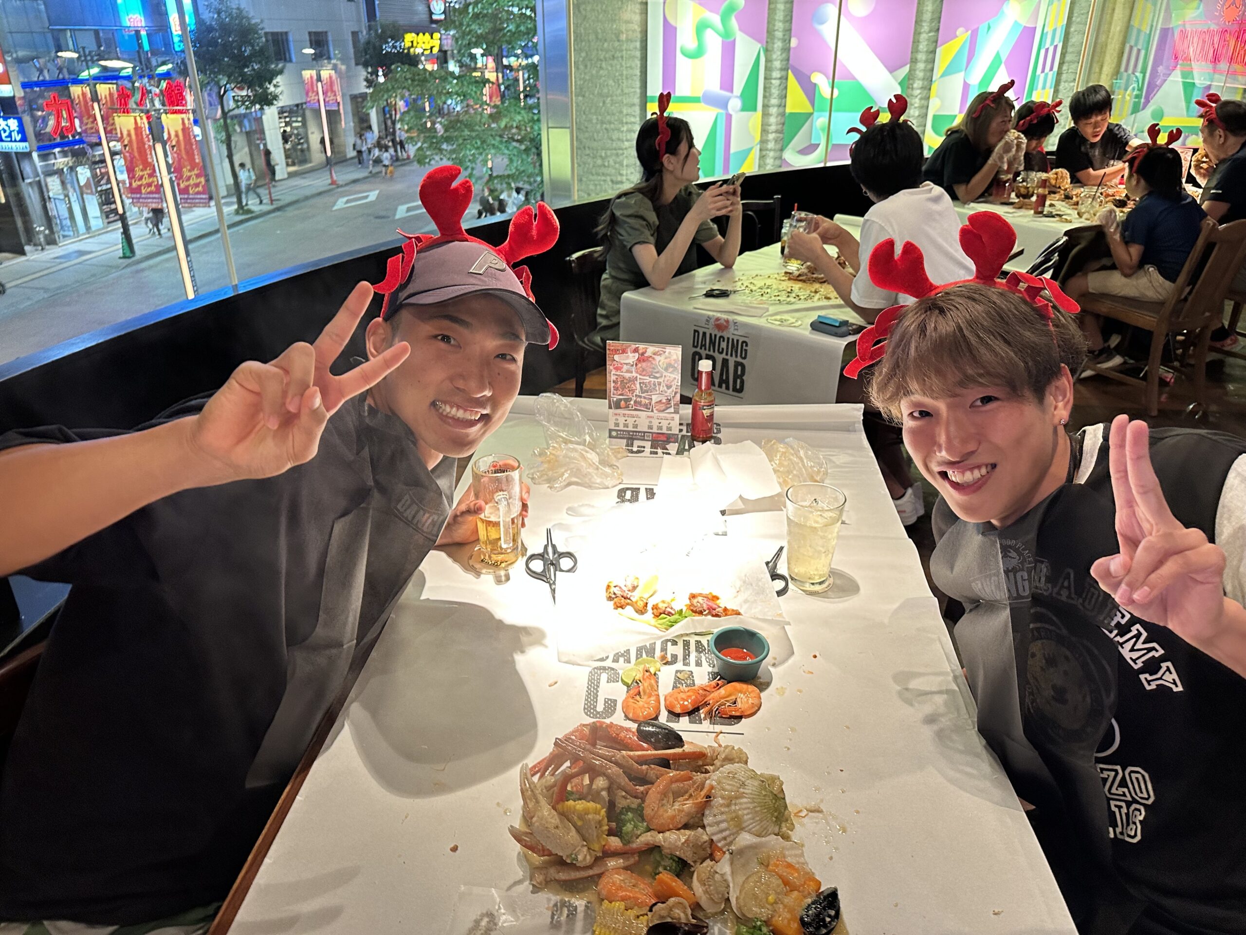 The photo of Izumiya and Maruyama making peace signs at a restaurant.