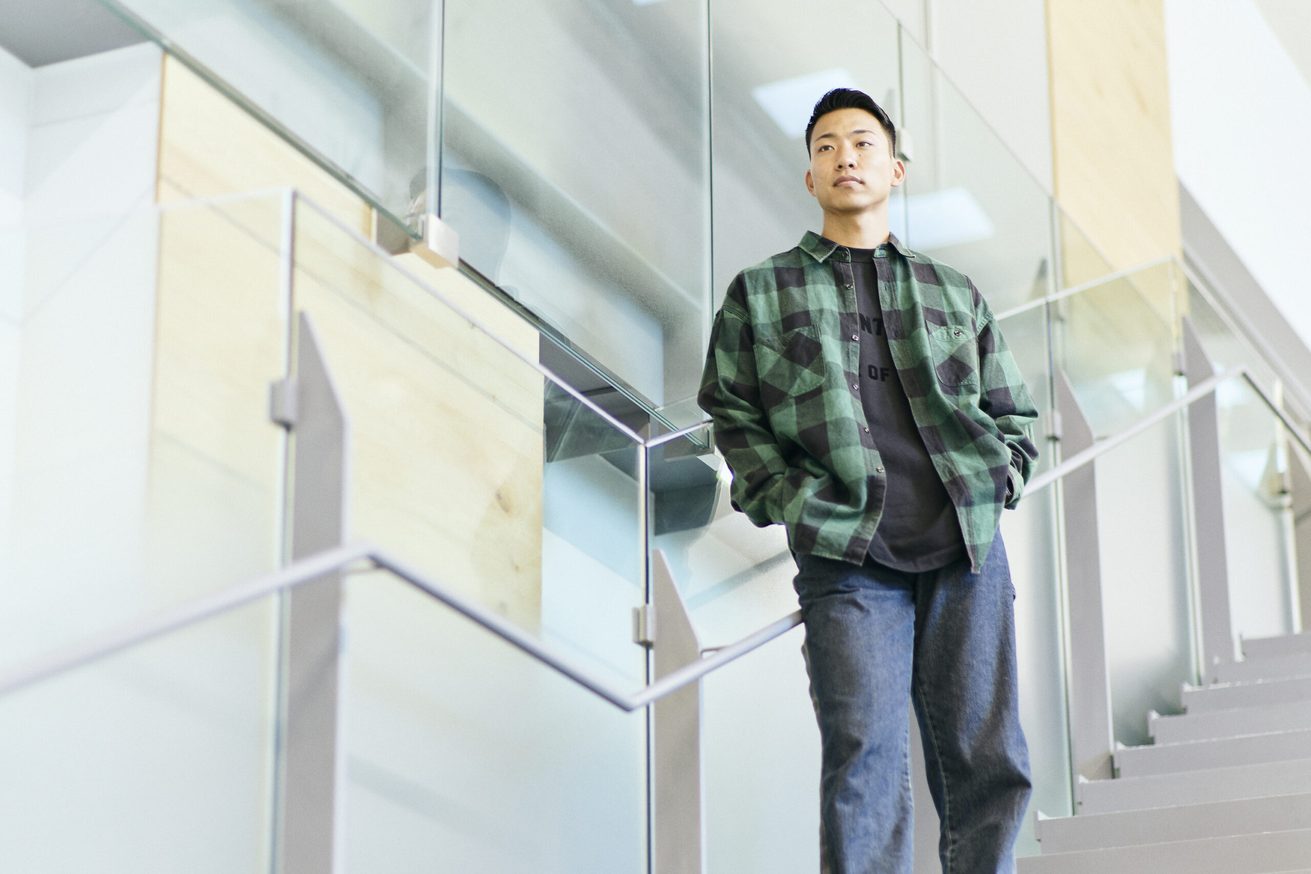 The photo of Maruyama leaning against the railing in the middle of the stairs.