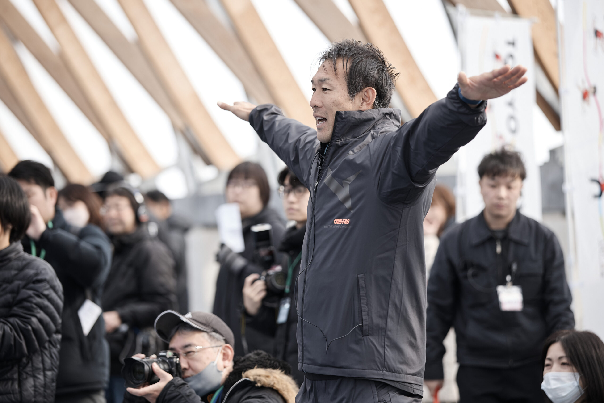 腕を横に広げている右代選手の写真