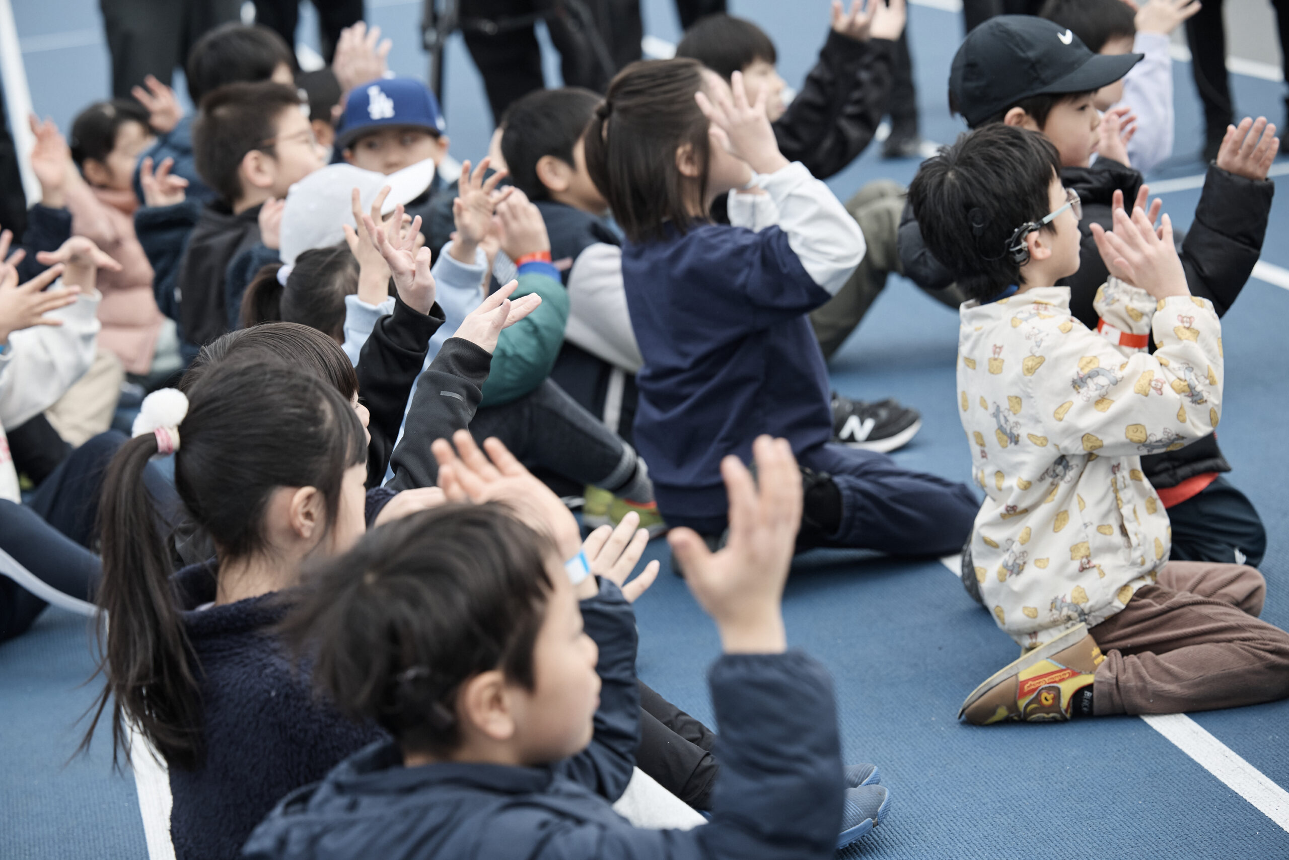 拍手の手話をしている子供たちの写真