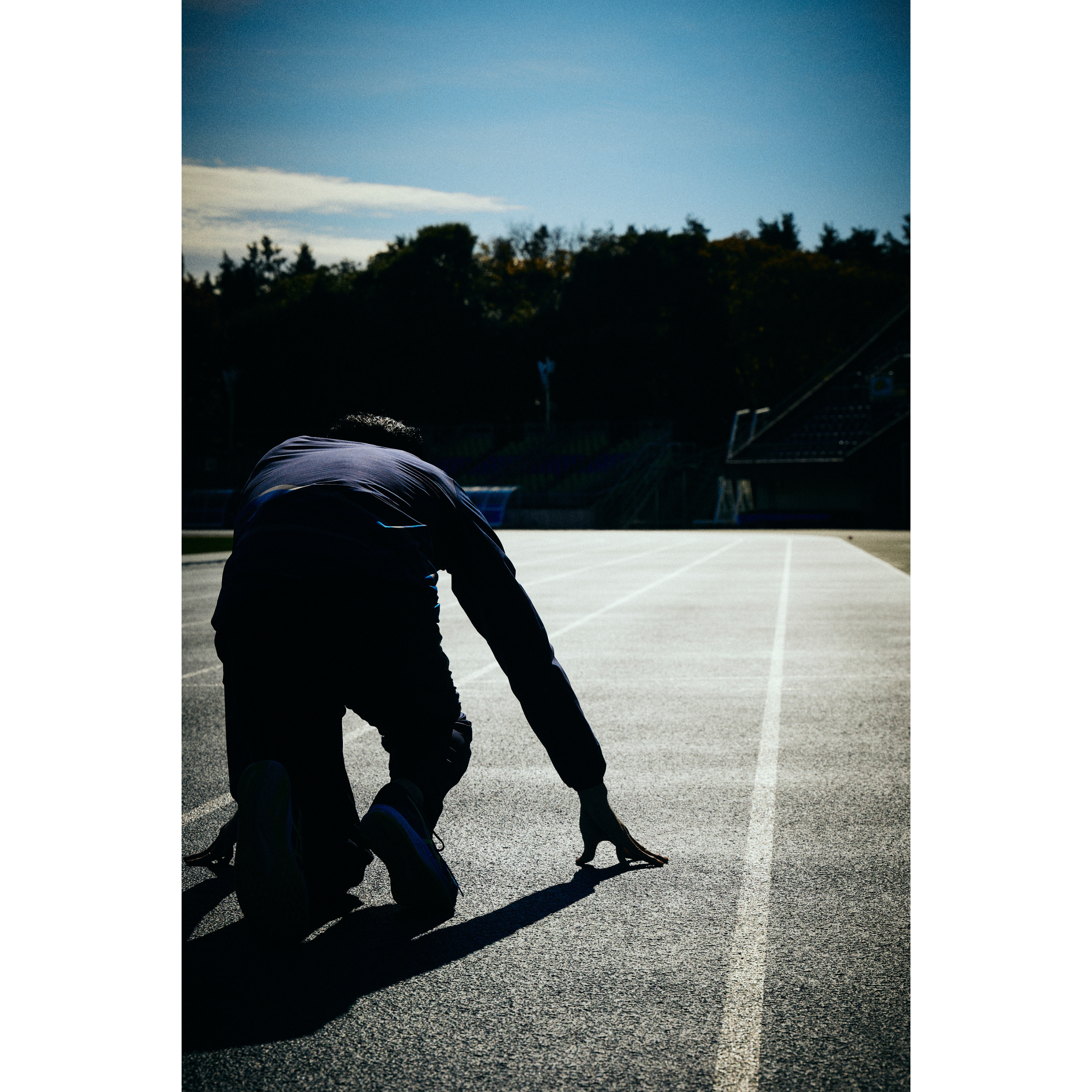 クラウチングスタートの姿勢をしている末續選手の写真