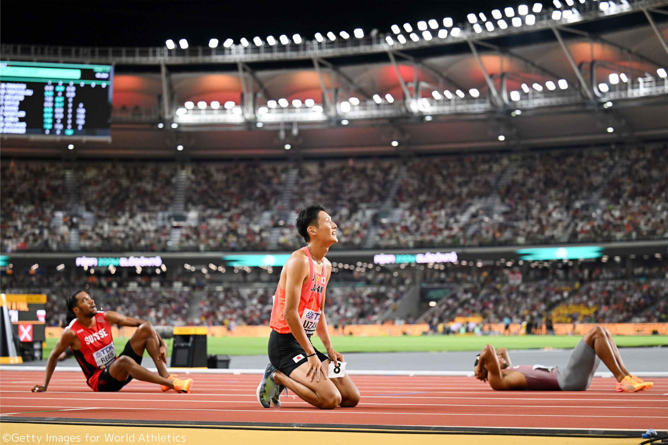 レース直後に立膝でスクリーンを見つめている鵜澤選手の写真