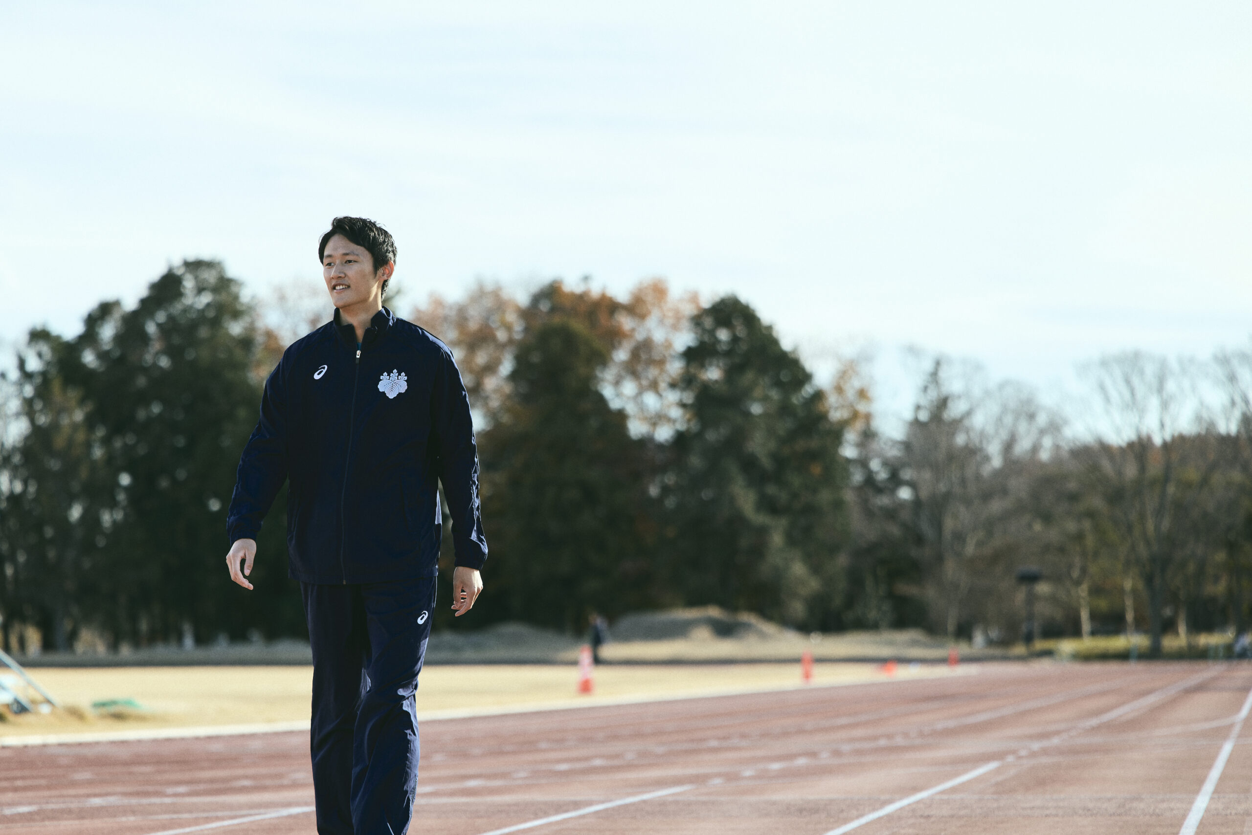 陸上トラックの上を歩いている鵜澤選手の写真