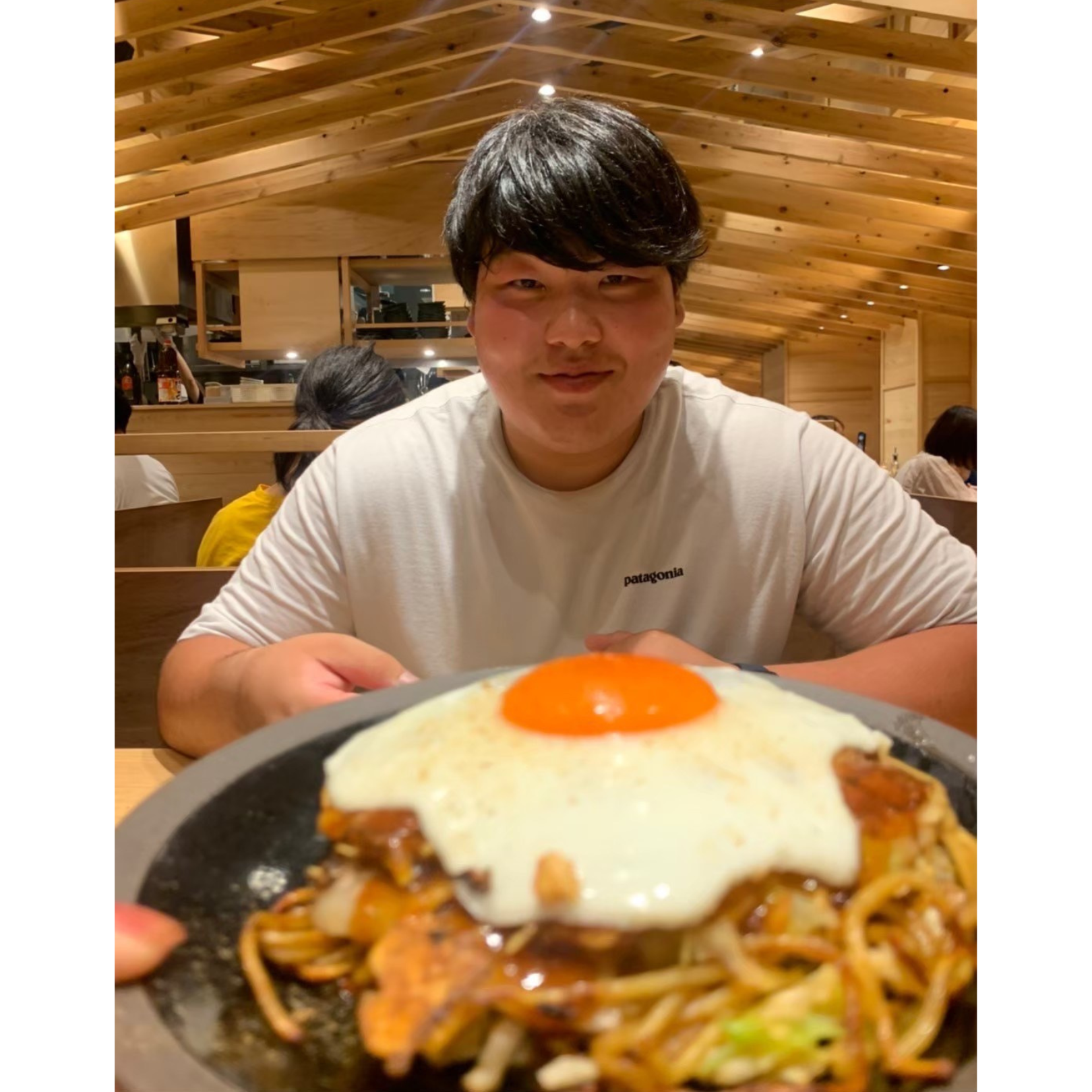 奥村選手の前に目玉焼きがのった焼きそばが写っている写真