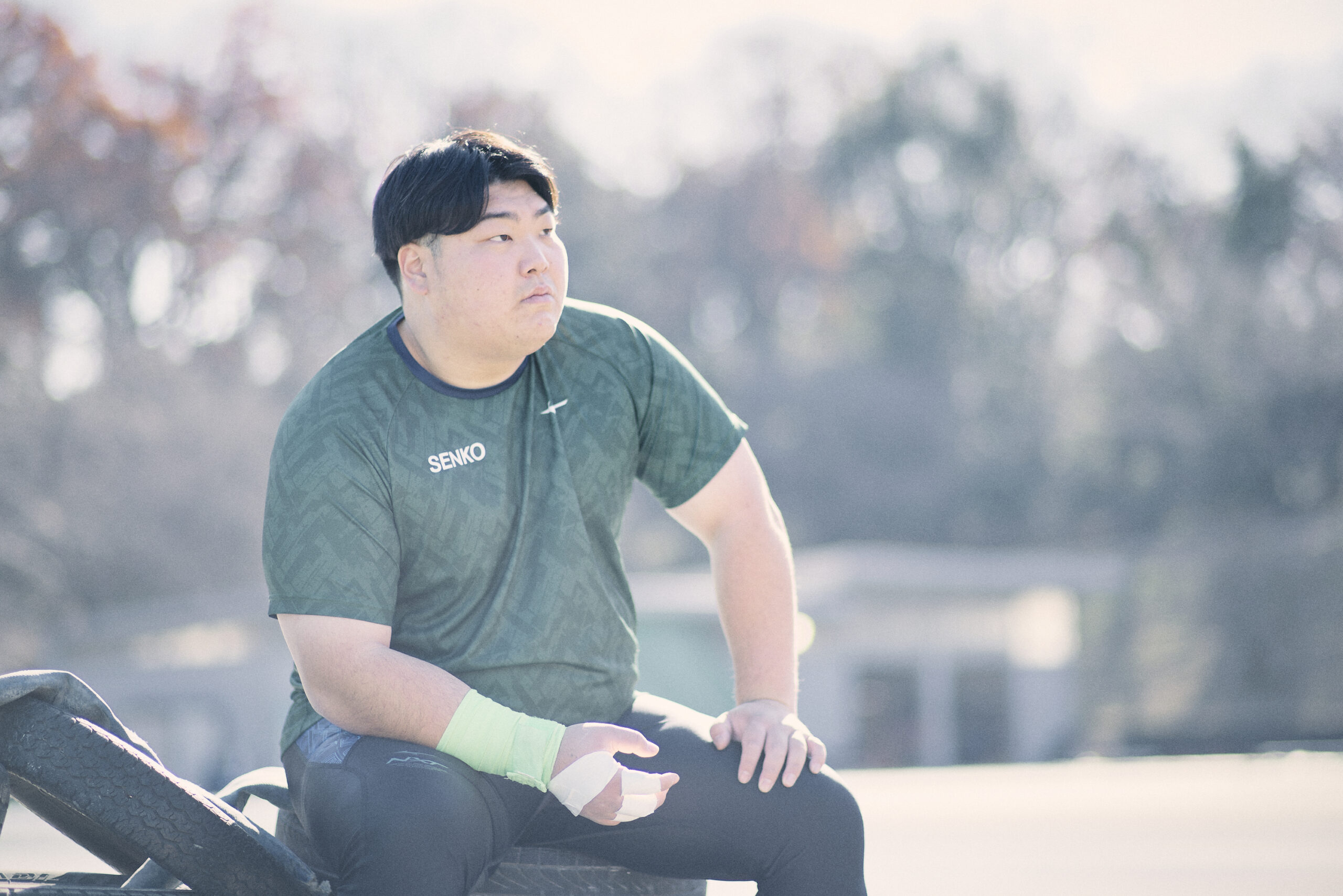 練習中にベンチに座って遠くを見つめている奥村選手の写真