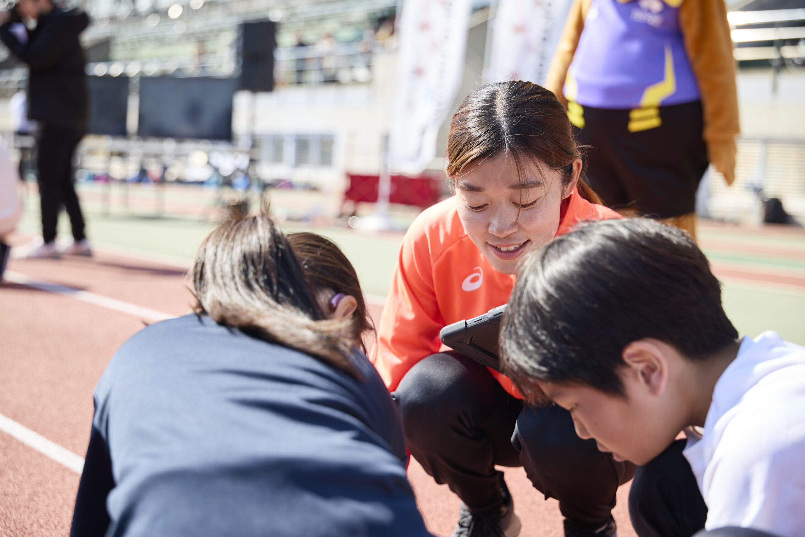 タブレットを操作している参加者を見守る岡田選手の写真