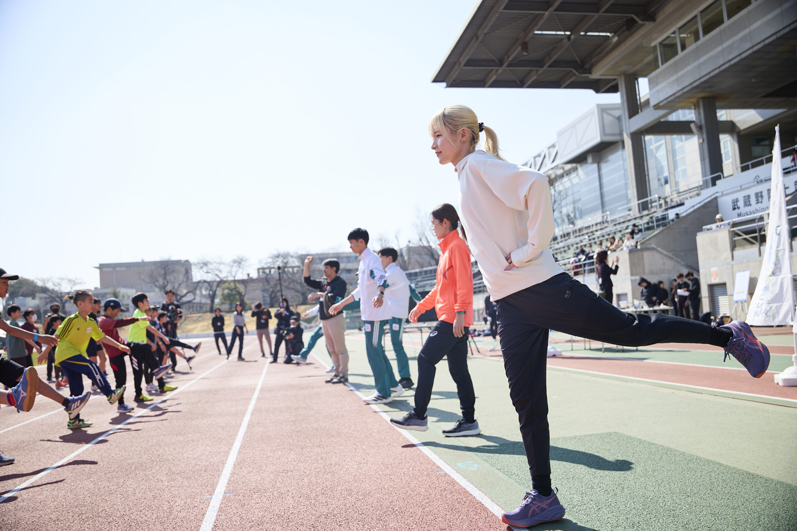 左脚を後ろにあげている志村さんと参加者の写真