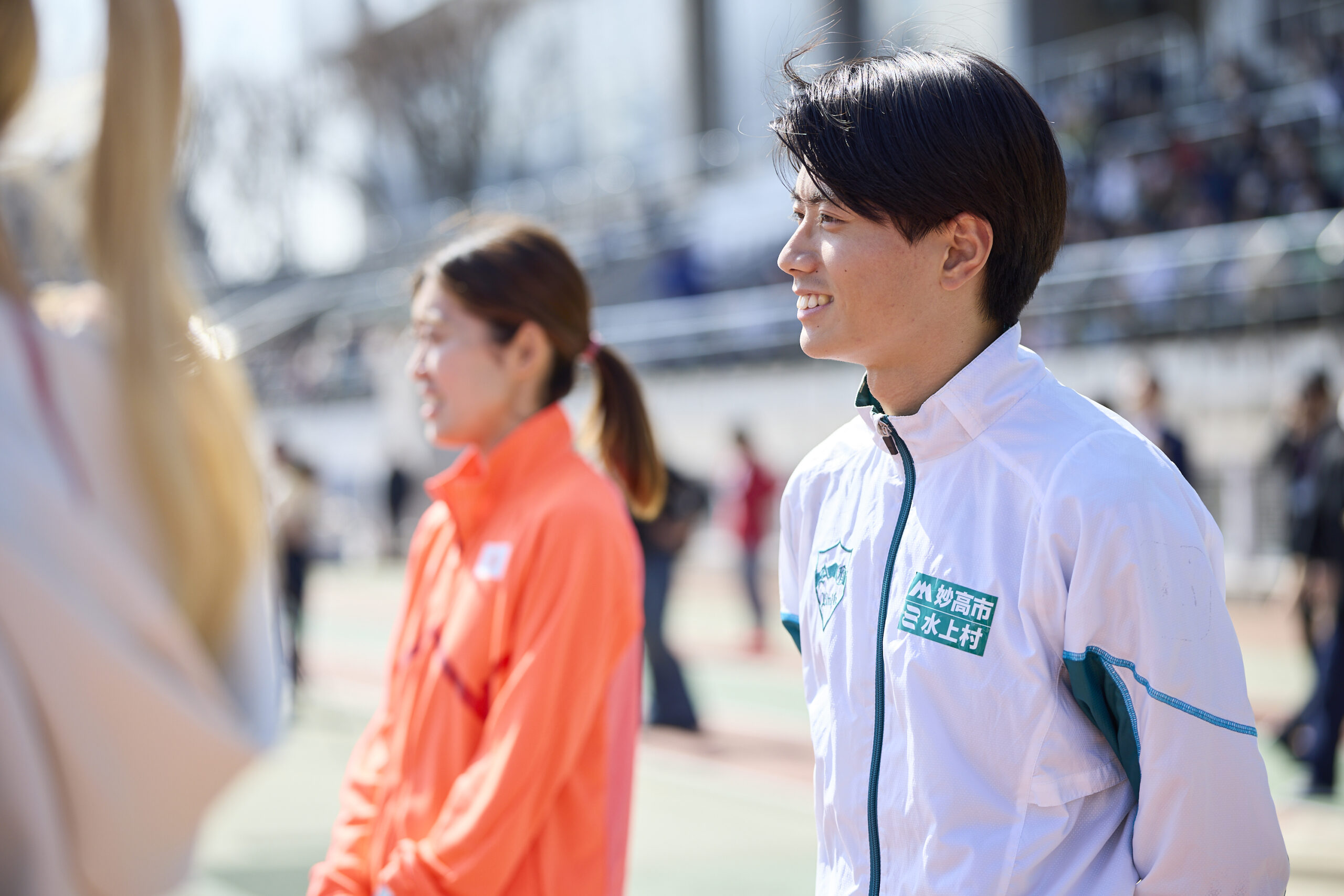 左方向を見ている若林選手とその後ろの岡田選手の写真