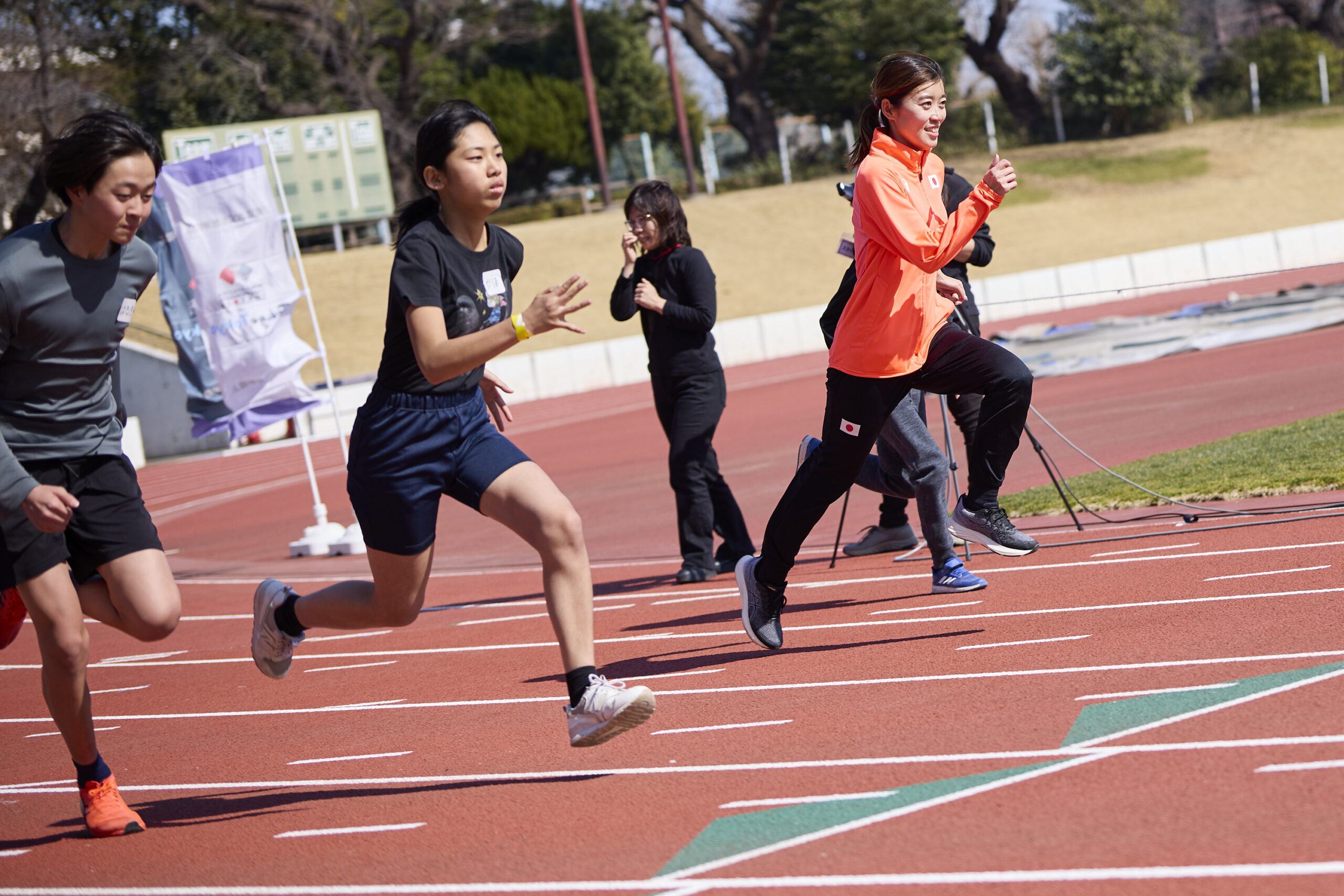 参加者と一緒にダッシュをしている岡田選手の写真