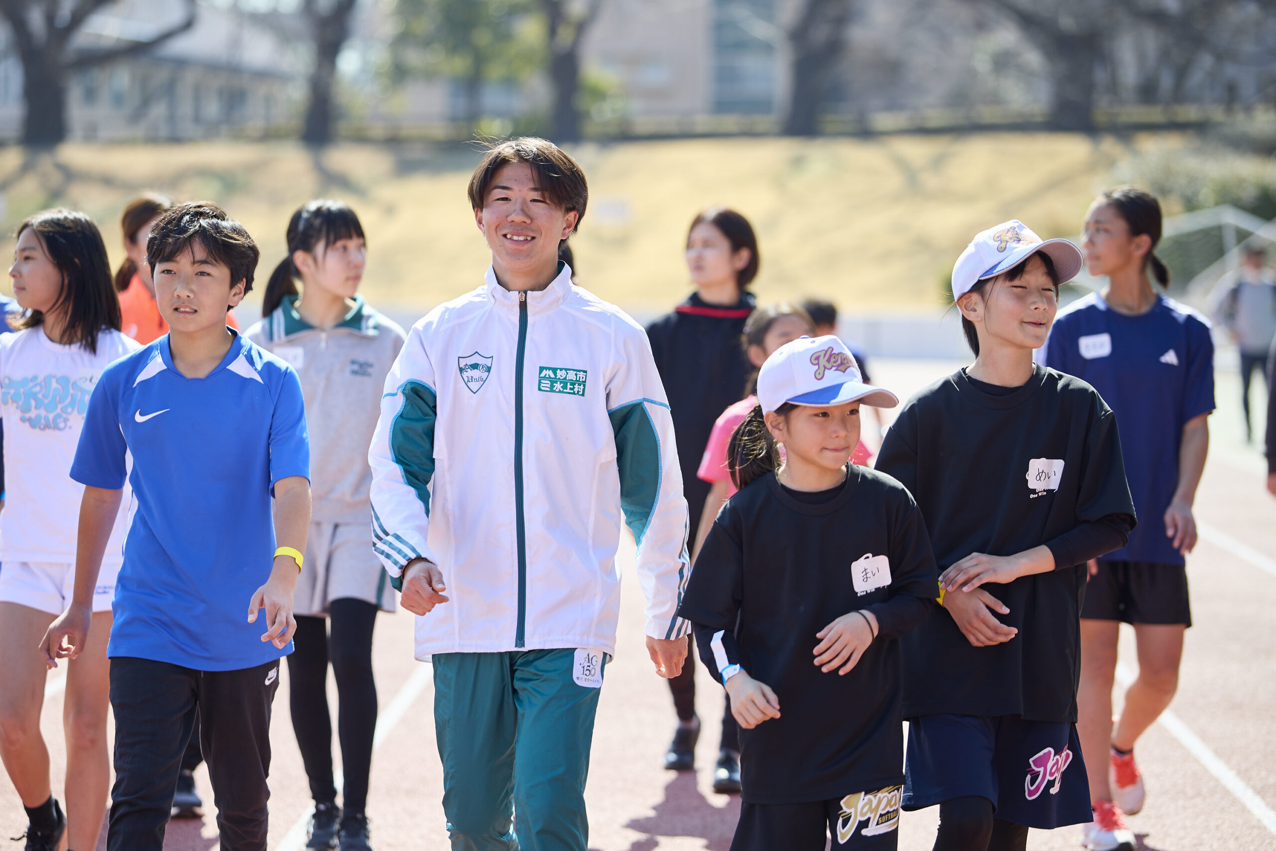 歩いている参加者と村上選手の写真